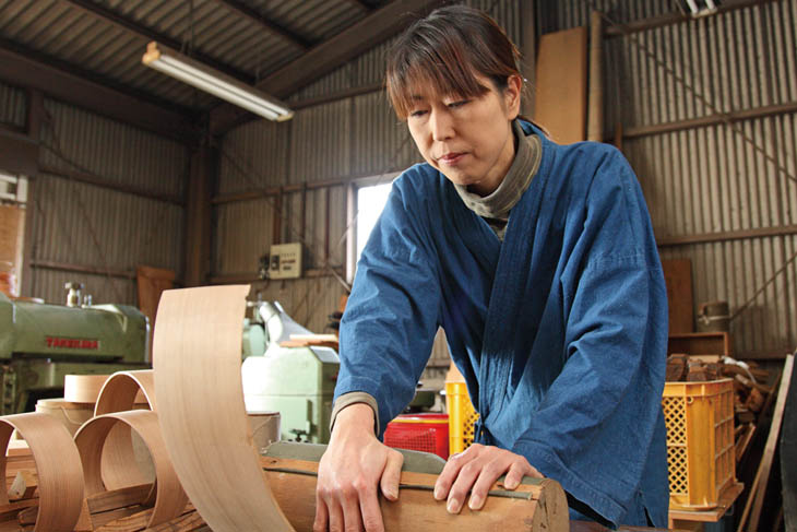 博多曲物玉樹の博多曲物師 柴田玉樹が巻木に板を巻きつけて曲げ加工をしています